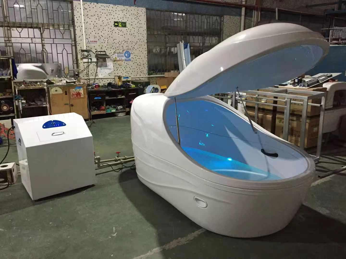 White GD576 floating pod with raised lid and separate control cabinet in the manufacturer's factory